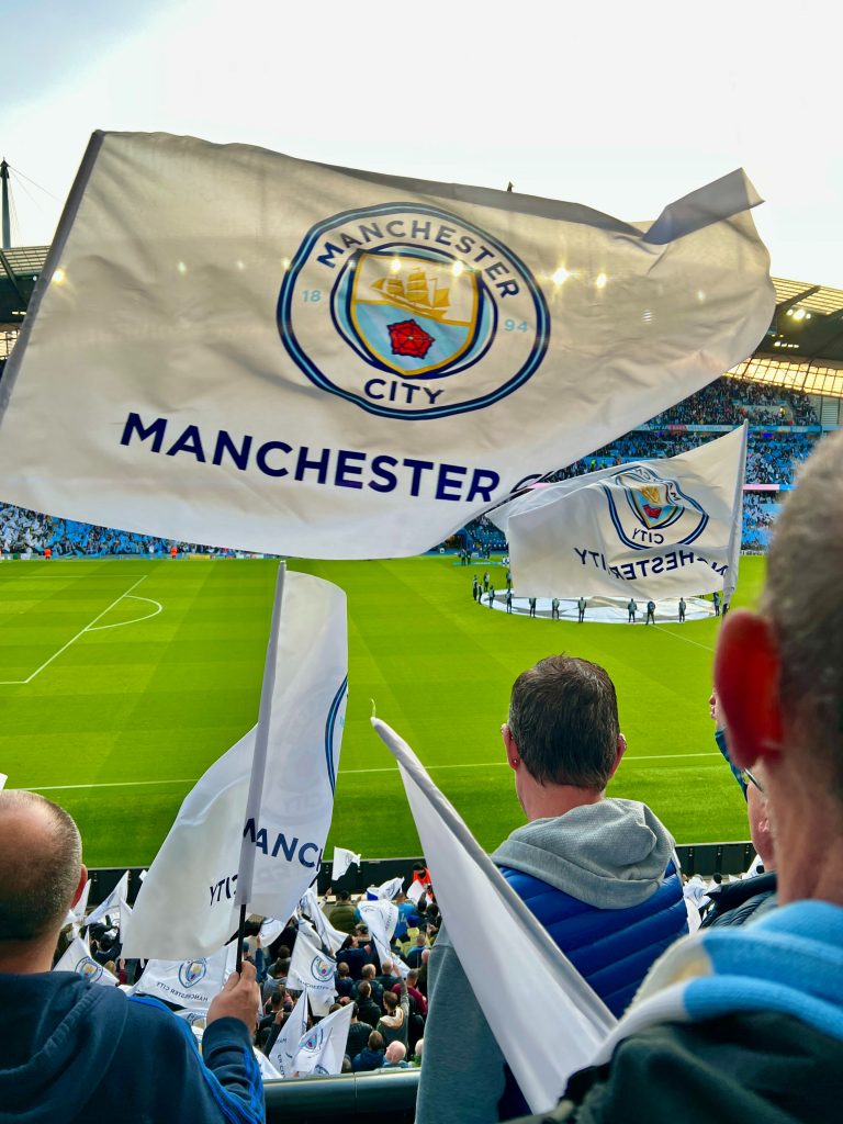 image représentant des supporteurs de Manchester city avec des drapeaux