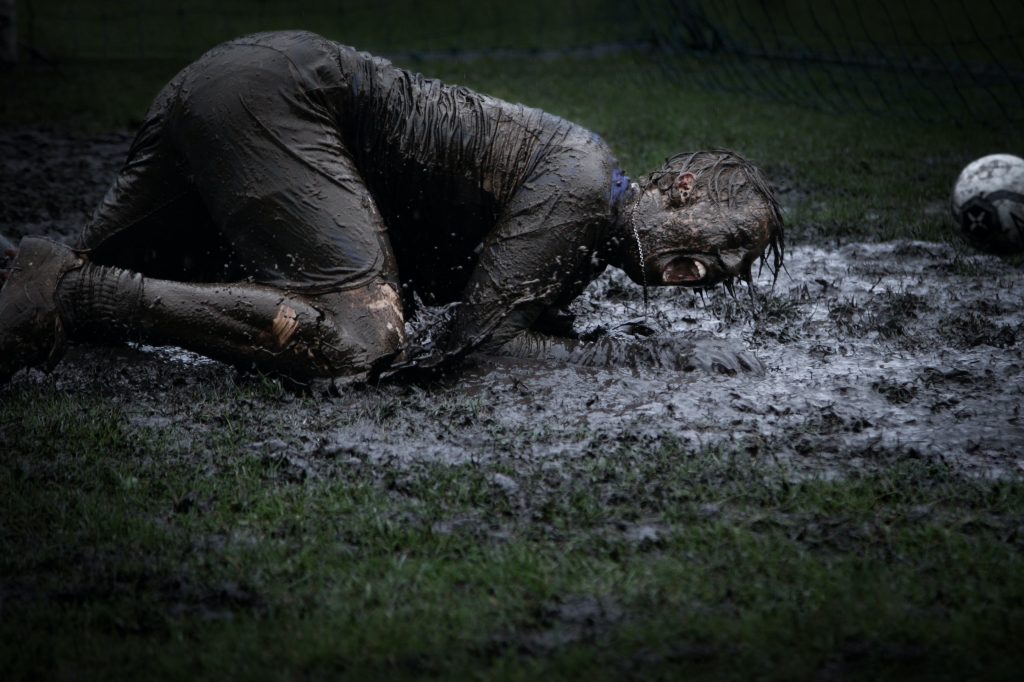 footballeur qui tombe dans la boue