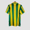 Maillot de match domicile du FC Nantes des années 90, avec larges rayures verticales vertes et jaunes, sponsor Eurest en noir, col à boutons.