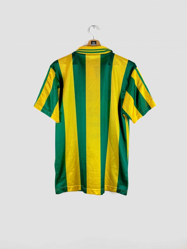 Maillot de match domicile du FC Nantes des années 90, avec larges rayures verticales vertes et jaunes, sponsor Eurest en noir, col à boutons.