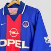 Ce maillot de foot vintage du PSG est une pièce rare pour les passionnés. Design iconique bleu et rouge avec le sponsor Opel, symbole de l’histoire du club parisien.