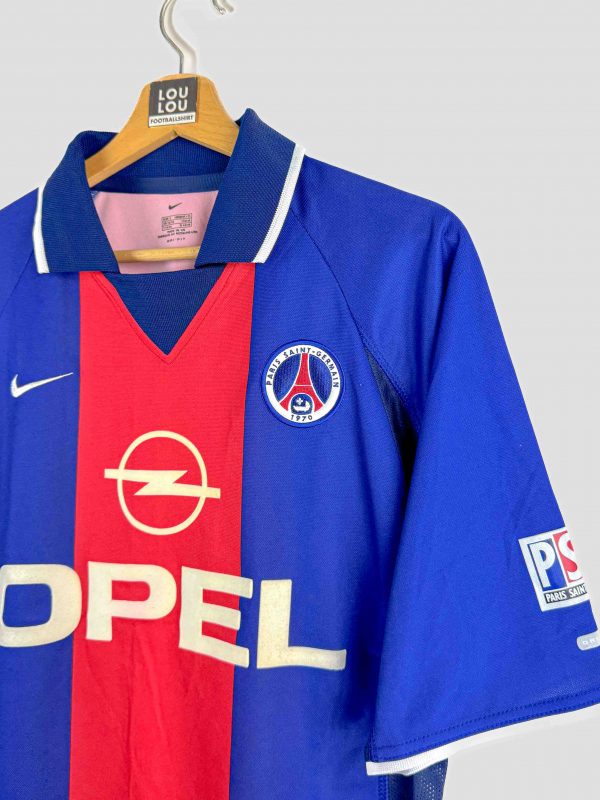 Ce maillot de foot vintage du PSG est une pièce rare pour les passionnés. Design iconique bleu et rouge avec le sponsor Opel, symbole de l’histoire du club parisien.