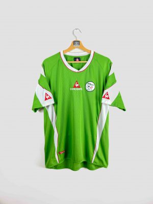 Maillot de foot vintage Algérie Le Coq Sportif, modèle vert avec détails blancs et rouges, logo de la Fédération Algérienne de Football sur la poitrine, édition rétro rare pour supporters et collectionneurs.