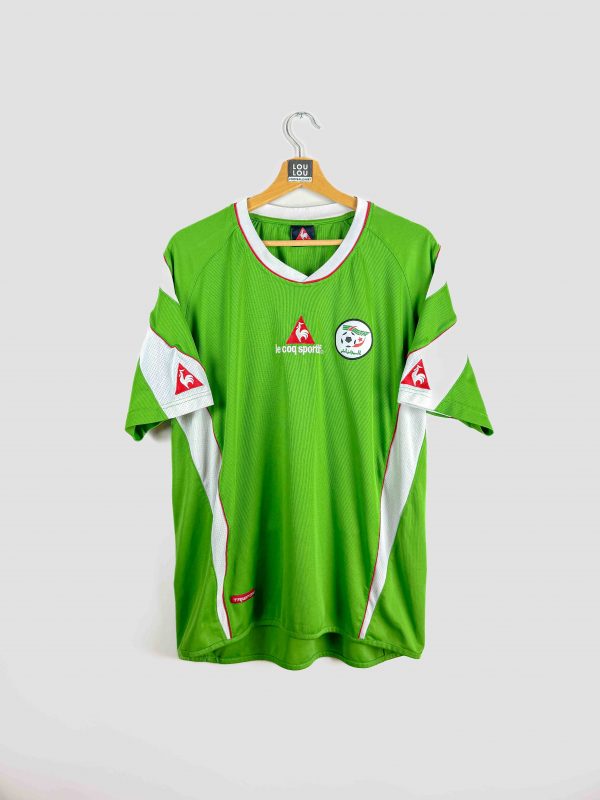 Maillot de foot vintage Algérie Le Coq Sportif, modèle vert avec détails blancs et rouges, logo de la Fédération Algérienne de Football sur la poitrine, édition rétro rare pour supporters et collectionneurs.