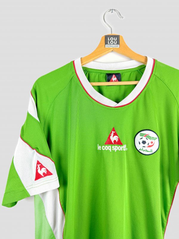 Maillot de foot rétro Algérie Le Coq Sportif, modèle vert avec détails blancs et rouges, logo de la Fédération Algérienne de Football sur la poitrine, édition rétro rare pour supporters et collectionneurs.