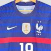 Gros plan sur l’écusson officiel de la FFF brodé sur le maillot Euro 2020, avec ses deux étoiles de champion du monde (1998, 2018).