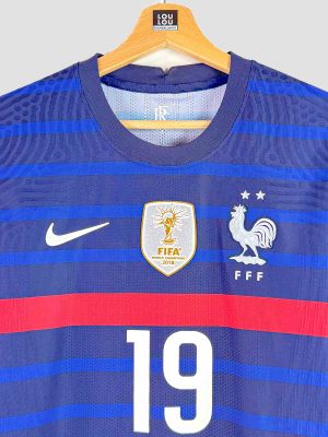 Gros plan sur l’écusson officiel de la FFF brodé sur le maillot Euro 2020, avec ses deux étoiles de champion du monde (1998, 2018).