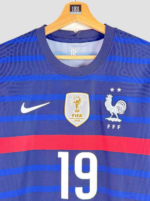 Gros plan sur l’écusson officiel de la FFF brodé sur le maillot Euro 2020, avec ses deux étoiles de champion du monde (1998, 2018).