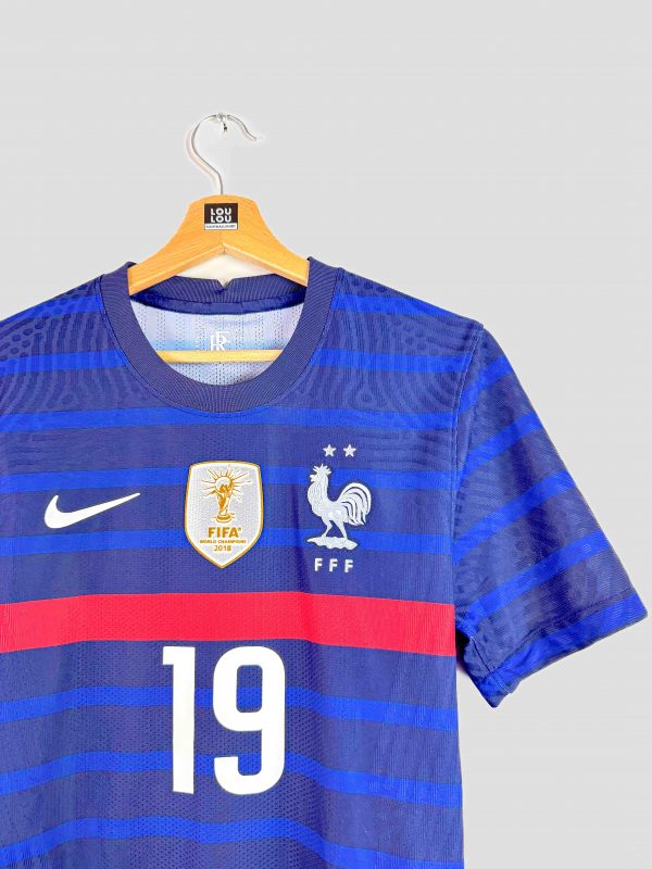 Zoom sur le badge doré FIFA Champions 2018 apposé sur la poitrine du maillot France Euro 2020, attestant du titre mondial en cours en 2018.