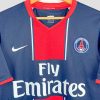 Détail du maillot vintage Paris Saint-Germain 2007 : écusson brodé et logo Nike sur fond bleu