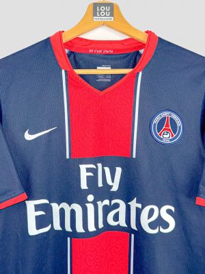 Détail du maillot vintage Paris Saint-Germain 2007 : écusson brodé et logo Nike sur fond bleu