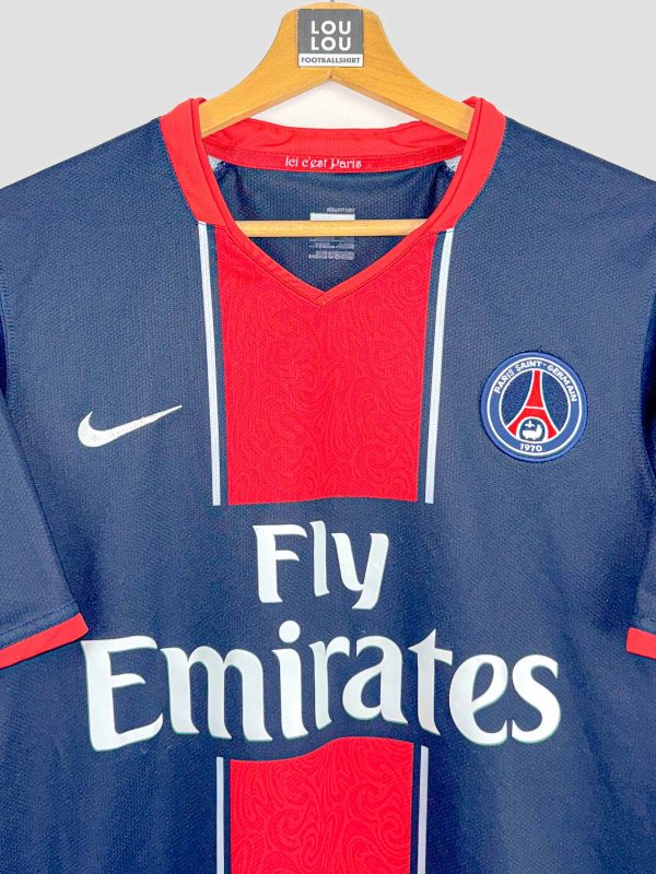 Détail du maillot vintage Paris Saint-Germain 2007 : écusson brodé et logo Nike sur fond bleu