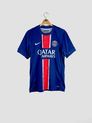 Vue avant du maillot domicile du PSG saison 2024-2025 avec bande rouge verticale effet coup de pinceau et sponsor Qatar Airways en blanc