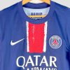 Gros plan sur l’écusson officiel du PSG présent sur la poitrine du maillot authentique 2024-2025, brodé en couleur sur fond bleu