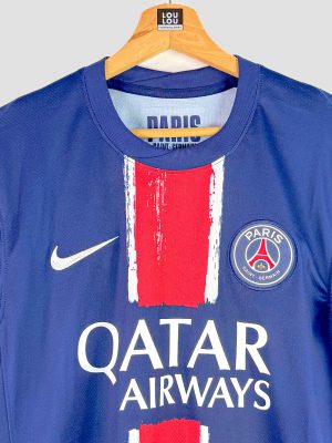 Gros plan sur l’écusson officiel du PSG présent sur la poitrine du maillot authentique 2024-2025, brodé en couleur sur fond bleu