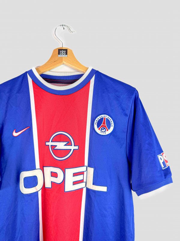 Écusson du PSG 1999 brodé sur le maillot rétro, soulignant l’authenticité du produit