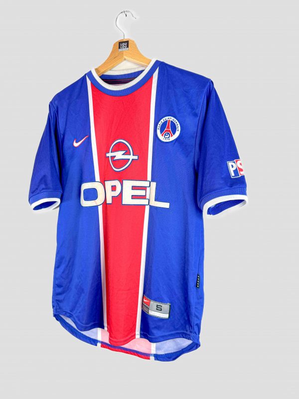 Détail du logo Opel en feutrine sur le maillot vintage PSG 99-00, signe du design d’époque