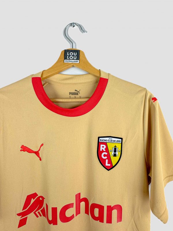 Maillot extérieur or du RC Lens saison 2023-2024 (édition Puma) photographié de profil, idéal pour les supporters souhaitant l’acheter.