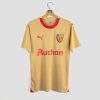 Vue de face du maillot extérieur 2023-2024 du RC Lens, coloris or avec le logo Puma et le sponsor Auchan au centre.