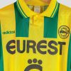 Maillot de football historique du FC Nantes, jaune et vert à rayures verticales, sponsor Eurest au centre, logo Adidas vert et blason du club.