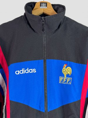 Détail du logo Adidas et de la broderie du coq français sur la veste équipe de France vintage Euro 1996, collection maillot rétro.
