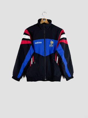 L’équipe de France posant en Angleterre lors de l’Euro 1996, vêtue de la veste équipe de France vintage emblématique de cette époque.