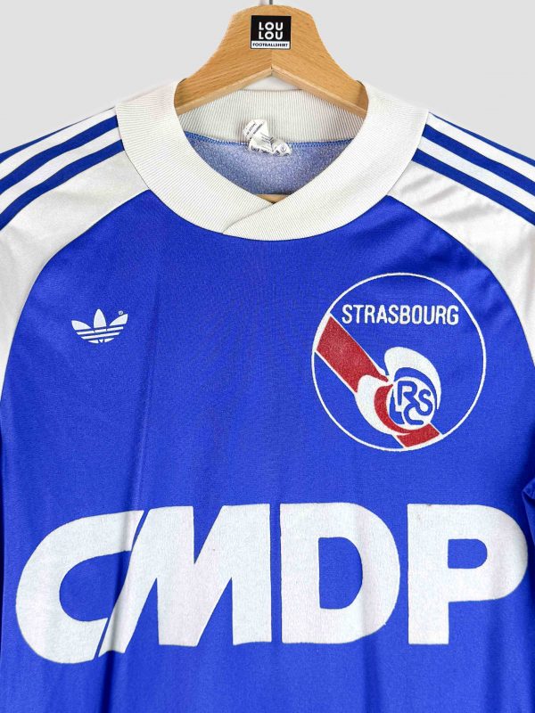 Détail du logo rétro et du sponsor d’époque sur le maillot vintage du RC Strasbourg 1978/1979